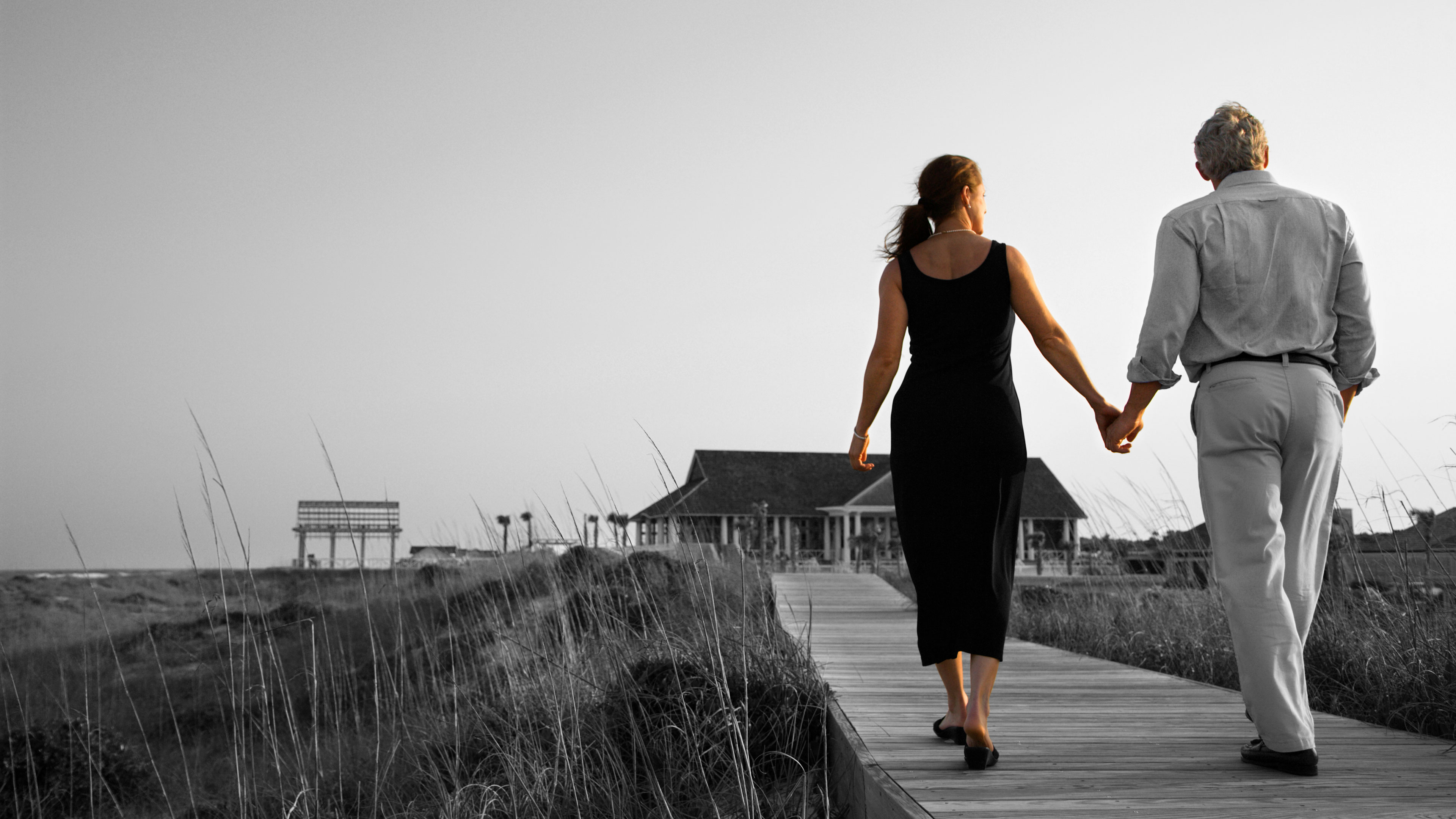 An older couple walking on a trail.